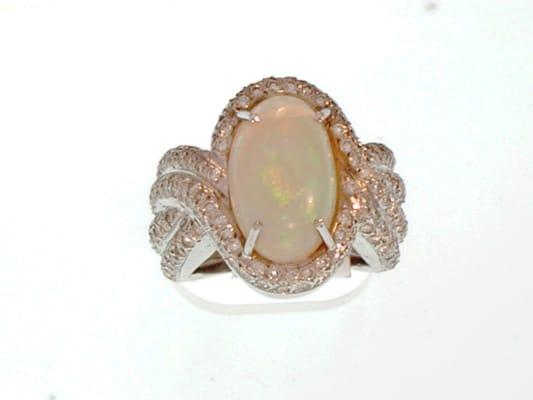 Custom-made ring in 18kt white gold, oval cabochon cut opal center, surrounded by pave set diamonds