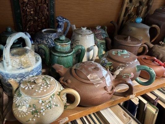 Beautiful tea pots and books underneath