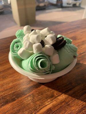 Mint chip rolled ice cream topped with Oreo, marshmallows and whipped cream