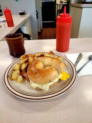 Ham fried egg and cheese on an everything begal with home fries