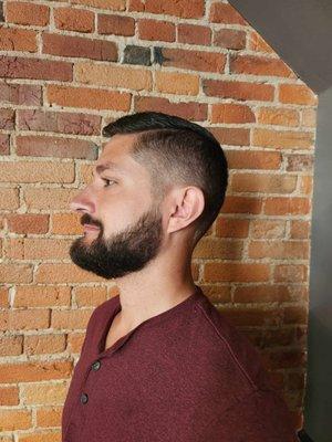 Men's bald fade haircut with a beard trim.