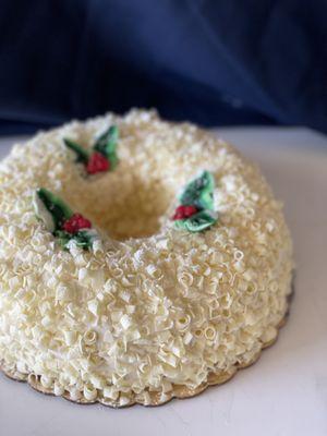 Wreath Cake - Yellow cake with Strawberry Buttercream filling, covered with French Buttercream and White Chocolate curls.