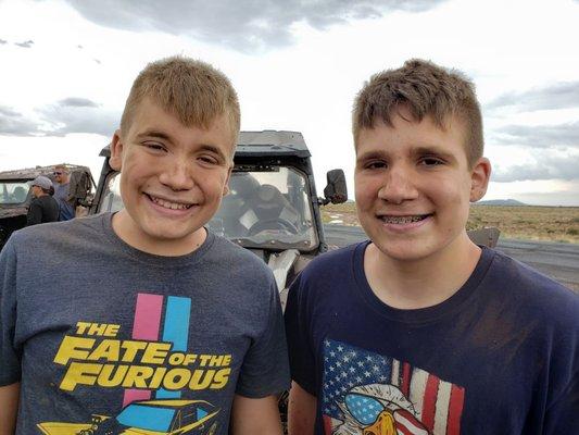 Happy boys on a break after riding through mud on way back