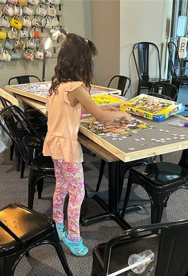 A young puzzler makes her contribution to the 300 piece puzzle.