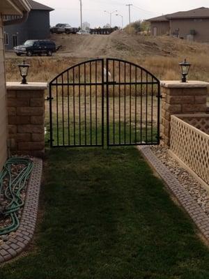 This unique back yard gate entrance is custom framed between two freestanding columns.