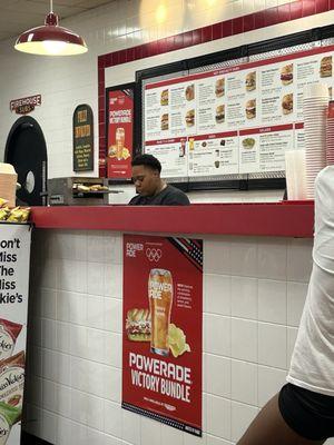 Employee chewing on gum while making subs