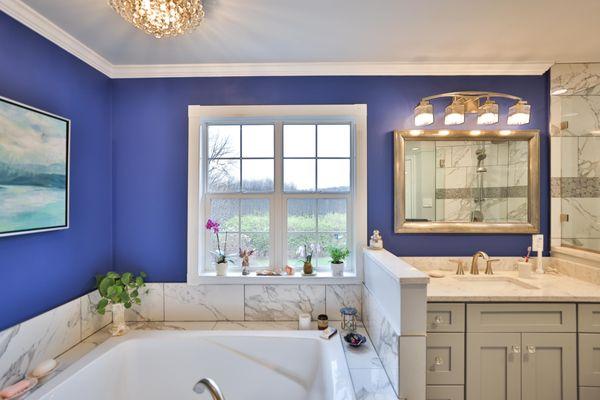 Master bathroom remodel with corner bathtub & marble lined tiles