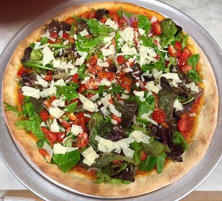 Mixed green tossed salad pizza topped with parmigiana cheese