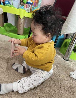 My son playing with a purse strap at daycare