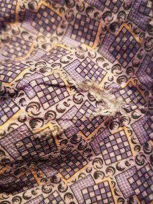 The inside of a cuff of a shirt that came back from Rose Cleaners with a cut that was not there before.