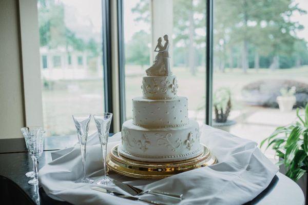 Almond-flavored wedding cake with buttercream icing and white-chocolate fleur de lis.