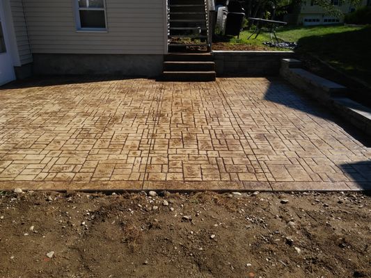 Stamped concrete patio with interlock retaining wall