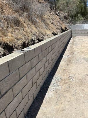 Cinder block retaining wall with electricity components.