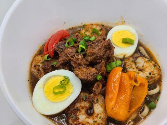 Yaka Mein Bowl- Fettuccine Noodles in a sweet savory Yaka Mein broth, topped with Braised Beef and Creole Shrimp, Boiled Egg and garnished a