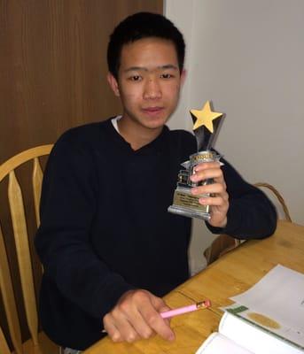 An ESL client receives a trophy after completing the "Reading InterVention" program.