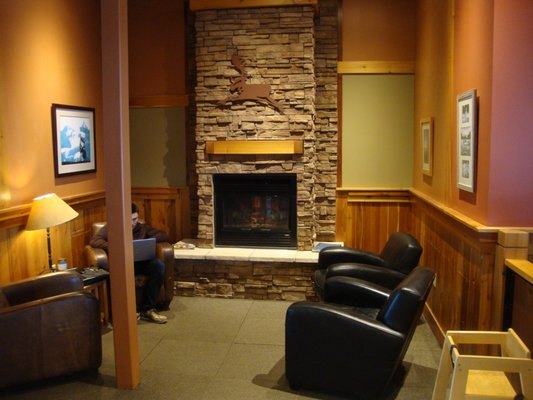 A warm little lounge area with a fireplace and comfy chairs.