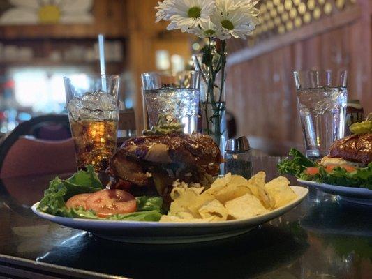 A close up of the bourbon burger, enjoyed on the table side of the grill. On the other side of the fence is a cute bar area.