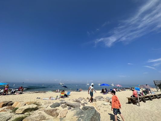 Beach goers relaxing on tiny Menemsha beach next to gas station