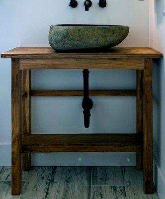 Sink made from river stone and teak base create a beautiful statement in any bath.