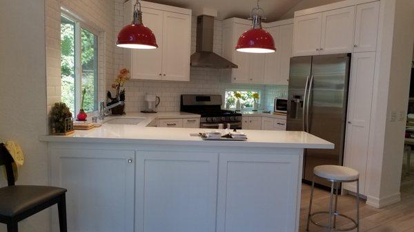 Quaint kitchen with custom shaker panel cabinets and quartz countertop.