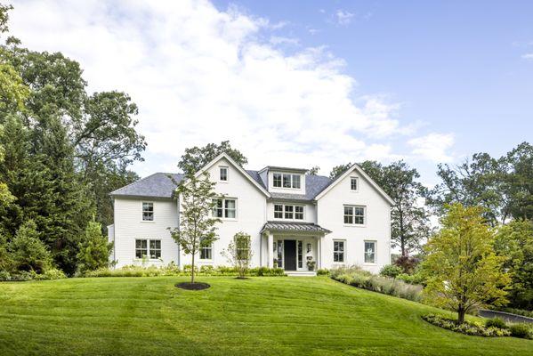 From facade featuring painted brick, clapboard siding, zinc accents and a slate roof.