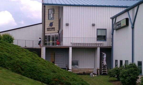 Spray Painting siding at the Oxford Club