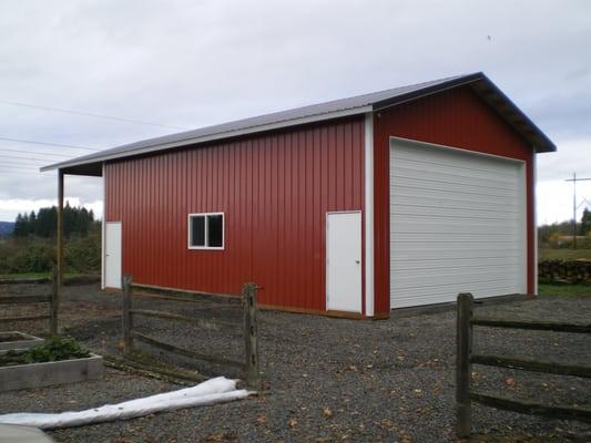 Simple shop with overhead garage door and gable end extension to be used as carport.