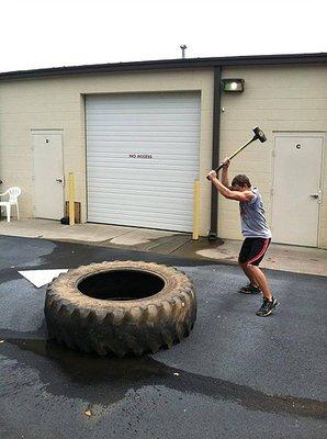 Outdoor area includes tires, sledge hammers, sleds and farmer's carry implements.