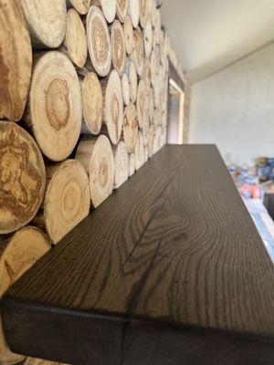 Aspens rounds backsplash with ebony stained reclaimed floating white oak shelf.