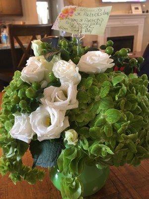 Beautiful greens and roses in a cute vase