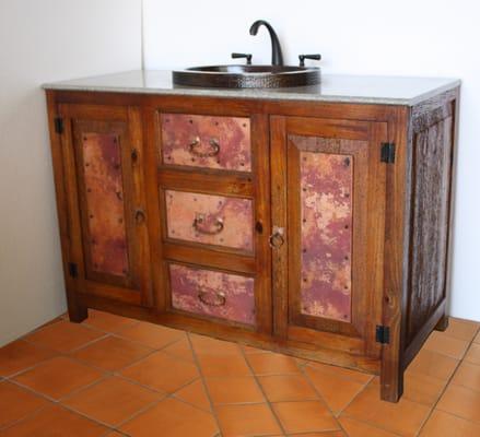 Pinewood vanity with s copper sink and oil rubbed bronze faucet.