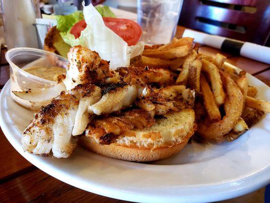 Grouper Sandwich- Blackened, topped with lettuce, tomato and tartar sauce on a Brioche bun. Handcut French fries on the side.