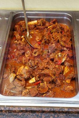 Stewed chicken, in the large hot food table.