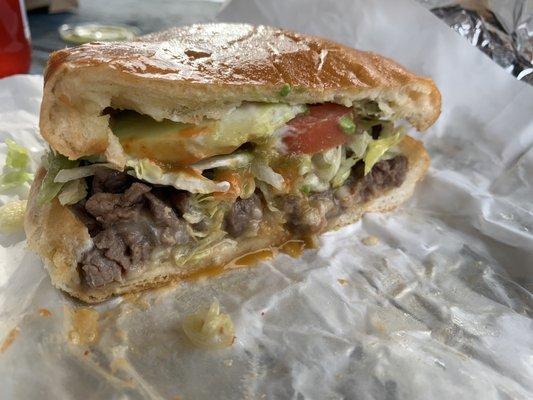 Torta de Asada includes mayo, lettuce, tomato, bean spread, avocado, chopped up streak, and telera bread.