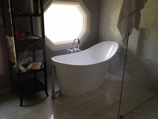 Freestanding acrylic bathtub after install.