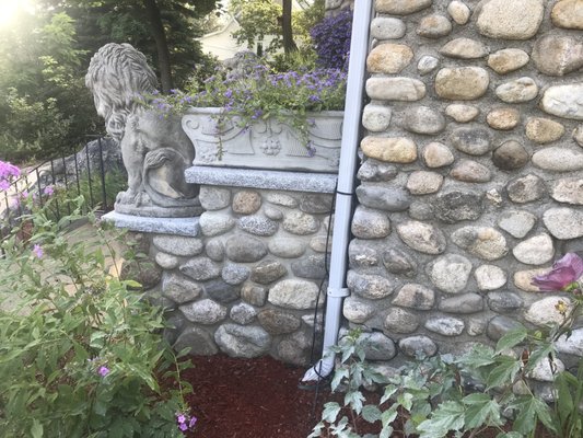 Right side of porch entrance. Stones match existing field stone porch &  chimney. Majestic lions proudly perched on granite pads.