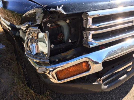 1990 Toyota Pickup damaged quarter panel, hood, grill, bumper, bumper under skirting, and headlight assembly