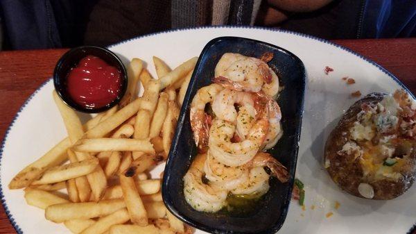 Shrimp scampi in butter sauce, fries and a loaded baked potato