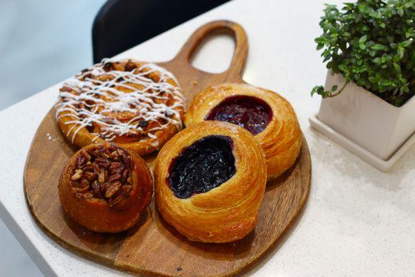 Arley's pastries: Cinnamon Roll, Pecan Sticky bun, & Rotating Danishes.