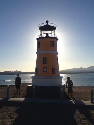 Light house overlooking the lake during sunset.