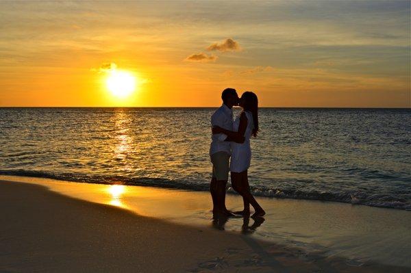 Couple kissing on romantic Eagle Beach.