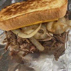 Brisket Melt! Shredded Brisket smothered in grilled onions and cheese, toasted on the grill!