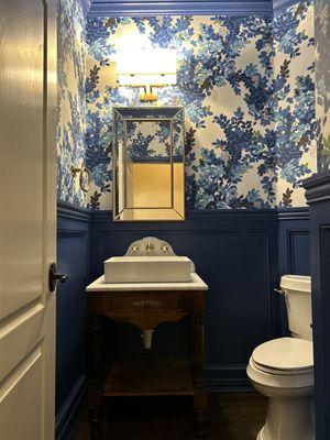 Paneled wainscoting, Thibaut wallpaper, Farrow & Ball "Dinnerware" paint, custom vanity and marble backsplash.  Stunning!