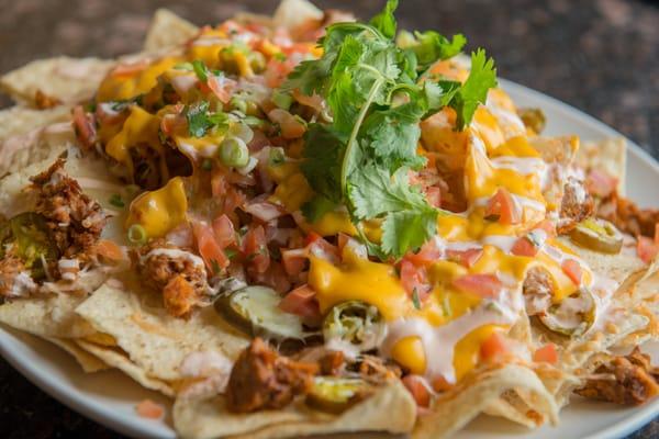 Red chili pork nachos with, avocado, cheese jalapenos, pico de galla, and spicy sour cream.