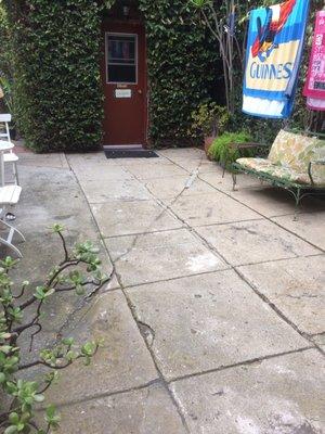 This is the back patio and the door to the laundry room. The furniture belongs to tenants. There are 2 clothes lines.