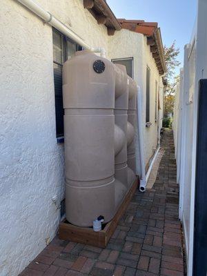 Our new 530 gallon rainwater capture system, neatly tucked away along our side walkway, ready to help us save water!