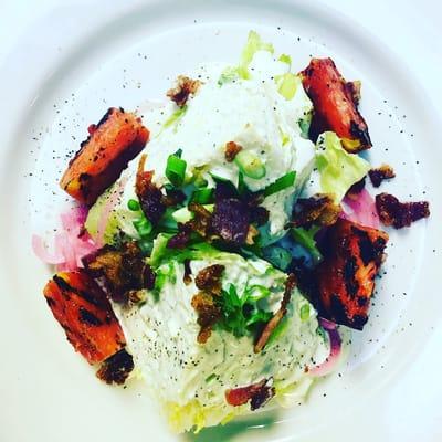 Wedge salad with crispy bacon grilled tomatoes, pickled red onion and house made blue cheese dressing