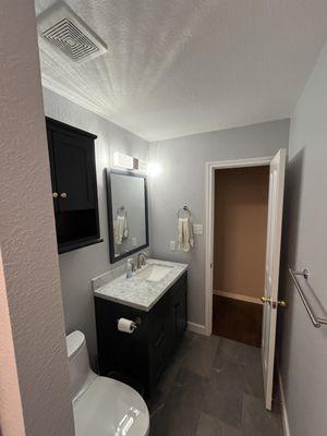 New Grey tile flooring with dark blue vanity and wall cabinet.  Wonderful!