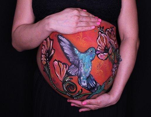 Maternity belly painting of humming bird by owner and artist Laura M Hoyos.