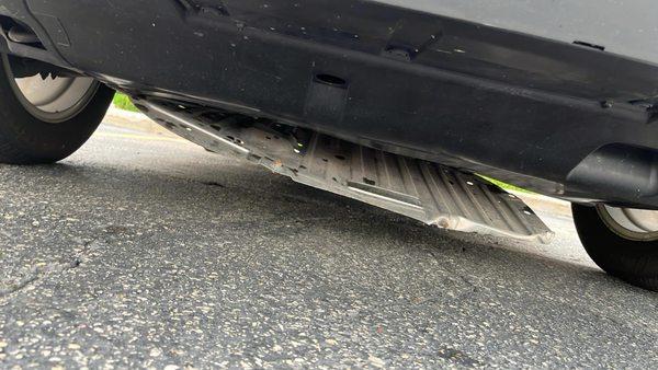 Another view of the fallen skip plate under the car.